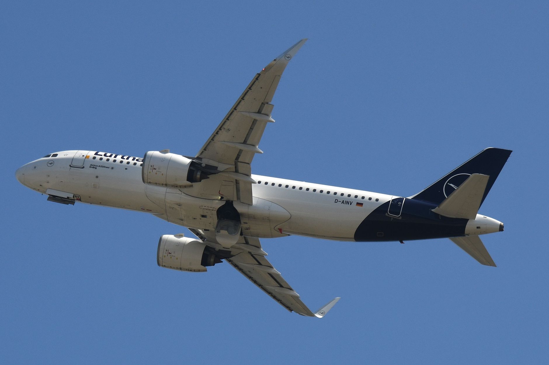 Airbus A320 aircraft in flight against a clear blue sky