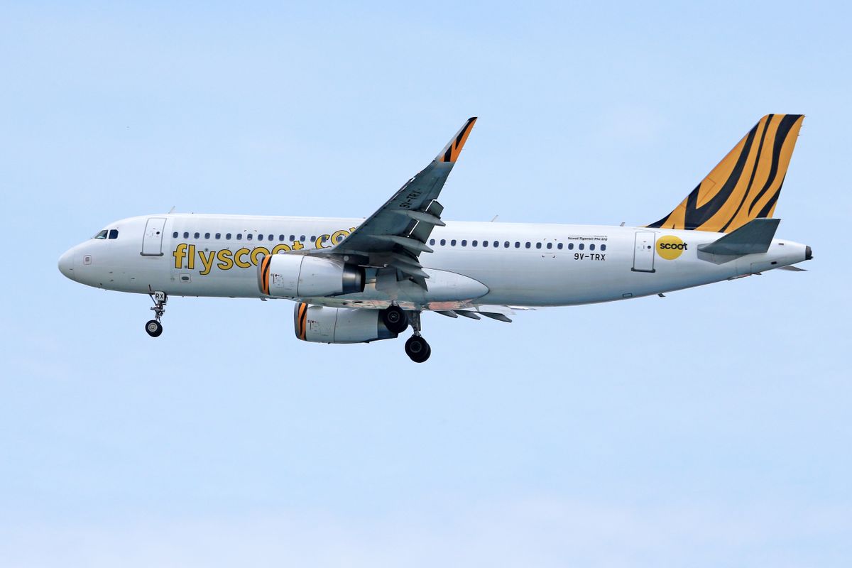 Scoot Airlines Airbus A320 flying high with Scoot branding against a clear blue sky