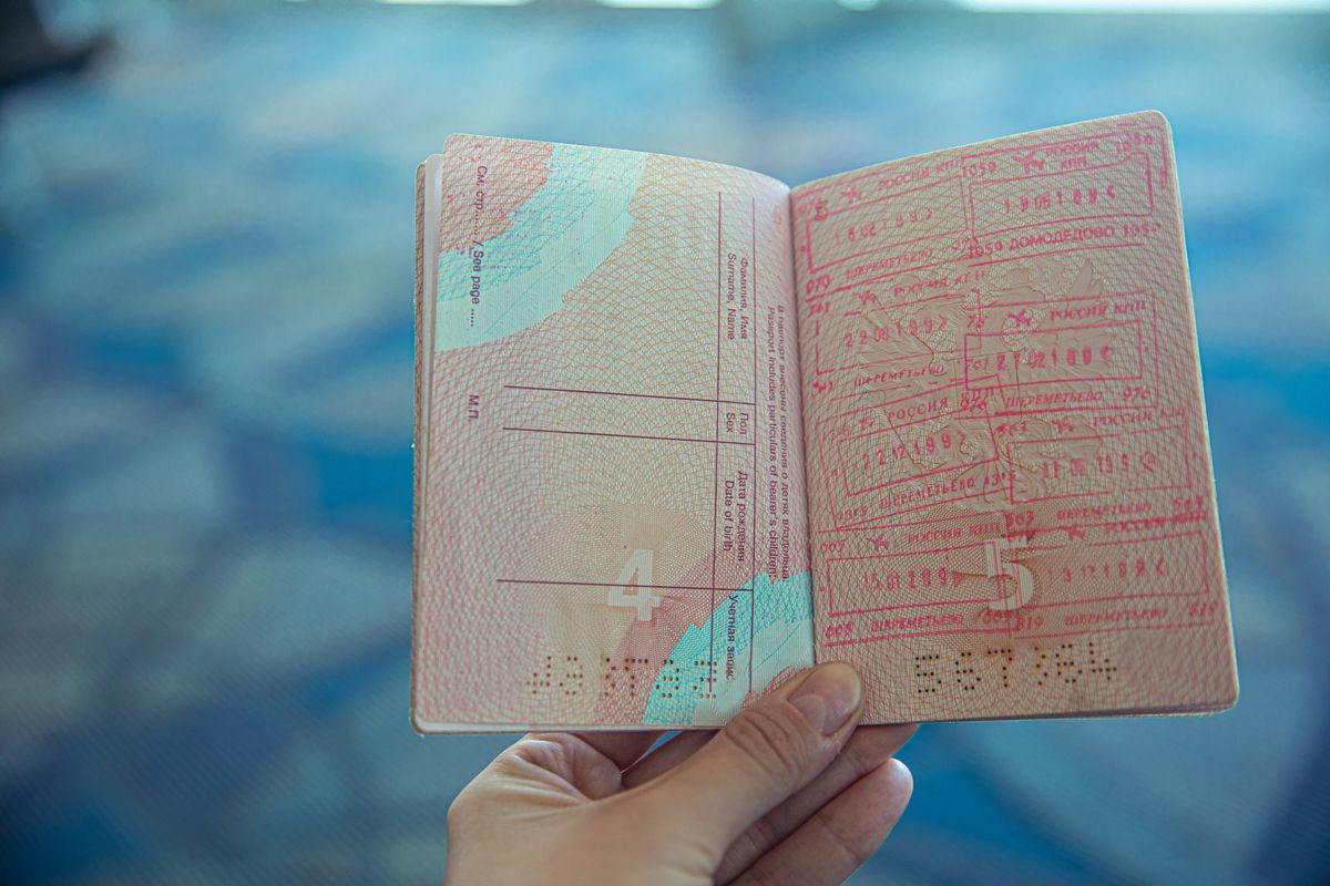 Close-up of an open passport displaying travel stamps — visa requirements for entering Thailand from Singapore